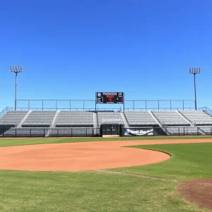 Empty baseball field with school banners indicating CIF probation impact