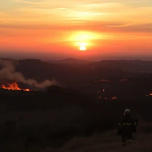 Firefighters battling wildfires in California during sunset